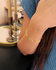 Model wearing 14K solid gold engravable bracelet while washing hands to show everyday use