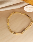 14K solid gold engravable bracelet with personalized name bars shown on wood background
