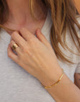 Model wearing 14K solid gold engravable bracelet with custom names engraved on links
