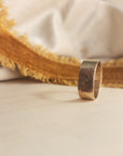 14K solid gold fingerprint band on wood surface with dramatic shadowing