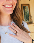 Woman smiling and wearing 14K solid gold fingerprint band with layered gold rings