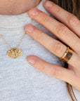 Woman wearing 14K solid gold fingerprint band with layered necklaces and stacked rings