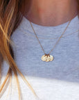 Personalized round tags from 14K solid gold name necklace on beige linen