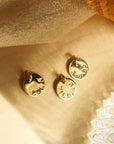 Personalized round tags from 14K solid gold name necklace on beige linen