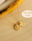 Flat lay of 14K solid gold name necklace with two hand-stamped tags on wood background