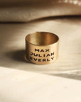 14K solid gold personalized band shown with engraved names in warm natural lighting