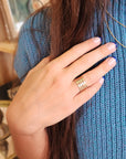 14K solid gold personalized band worn on model's hand with blue knit sweater