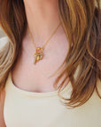 Model wearing 18k gold plated PVD add-on charms on gold chain necklace with butterfly and heart charms