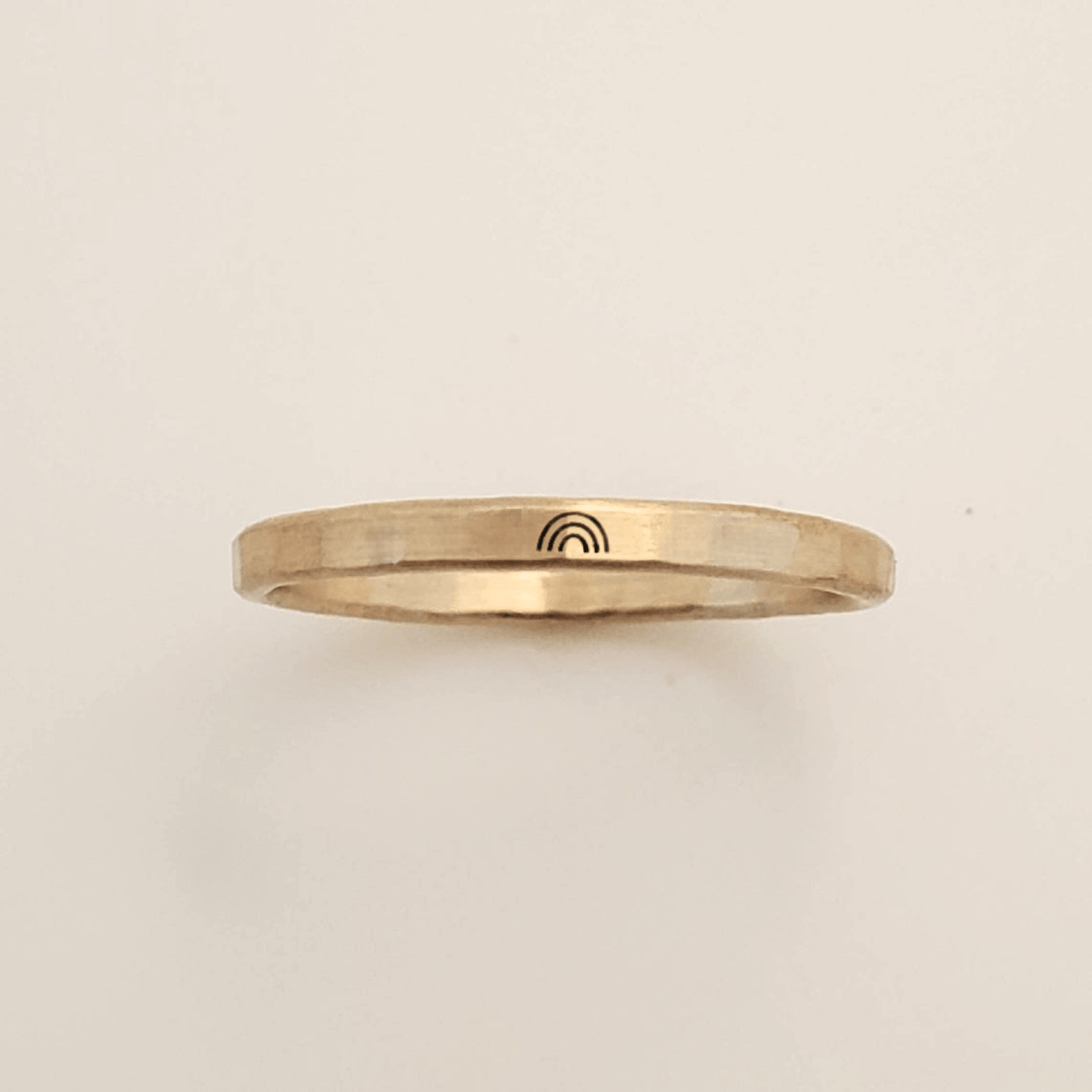 Minimalist rainbow ring with hand-stamped rainbow symbol on hammered gold band