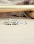 Three silver rings displayed on a wood table
