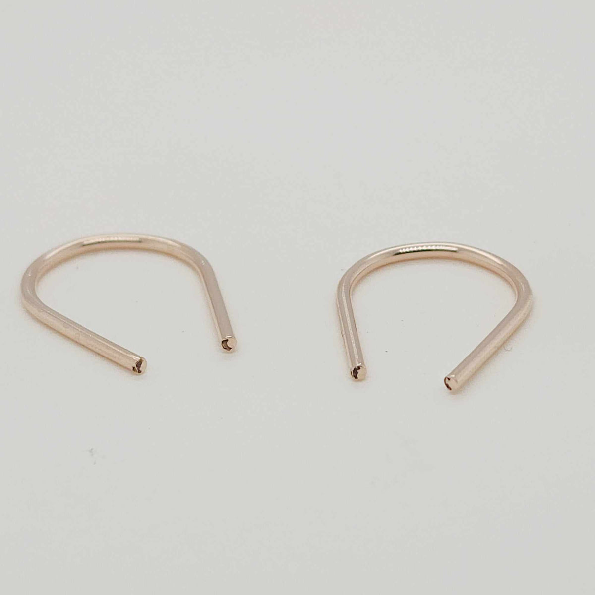 Angled view of gold U-shaped earrings for modern jewelry styling