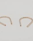 Angled view of gold U-shaped earrings for modern jewelry styling