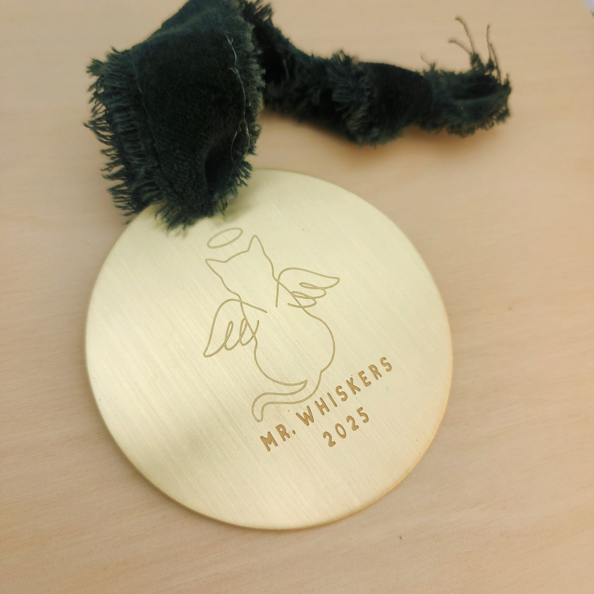 Gold round ornament with cat illustration and 'Mr. Whiskers 2025' text on a beige background