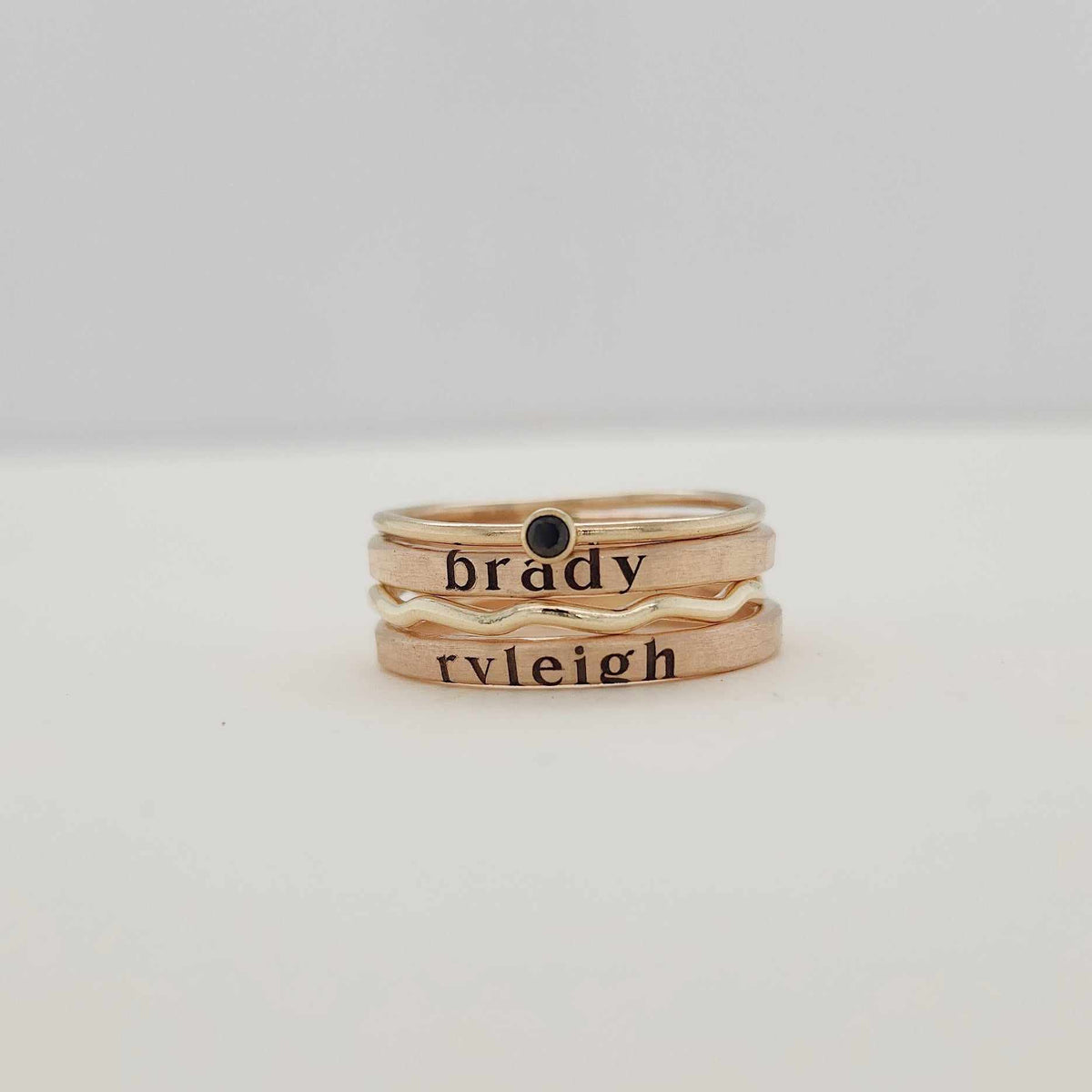 A stack of gold-filled rings, with the focus on the rings' texture and shine.