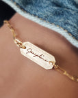 A gold-filled bracelet with a personalized signature tag on a person's wrist, showing the name 'Jessica'.