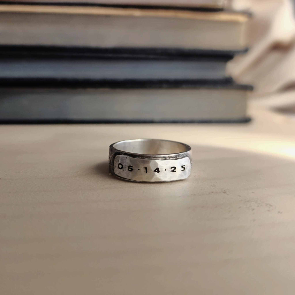 Silver ring with engraved numbers on a stone surface