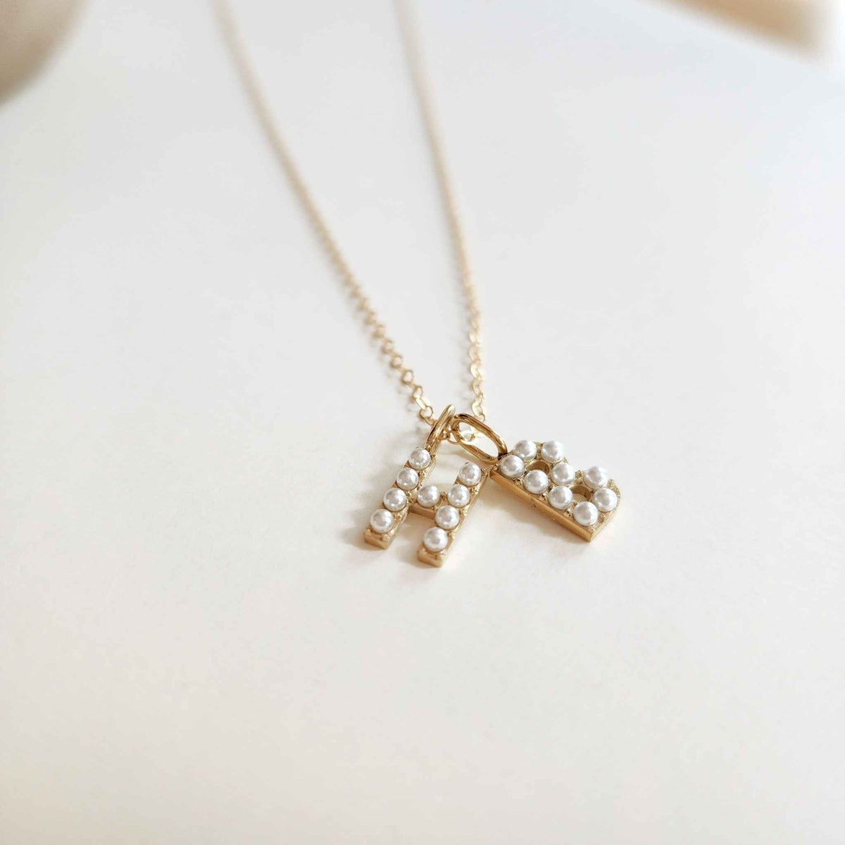 Pearl initial necklace with letter 'H' and 'B'