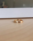 A gold filled personalized stacking ring with the name 'liv\ engraved on it, displayed on a wooden surface.