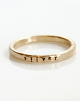 Single 14k gold-filled name ring stamped with small font saying a kid's name