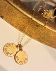 Gold necklace with engraved pendants on a gold stand