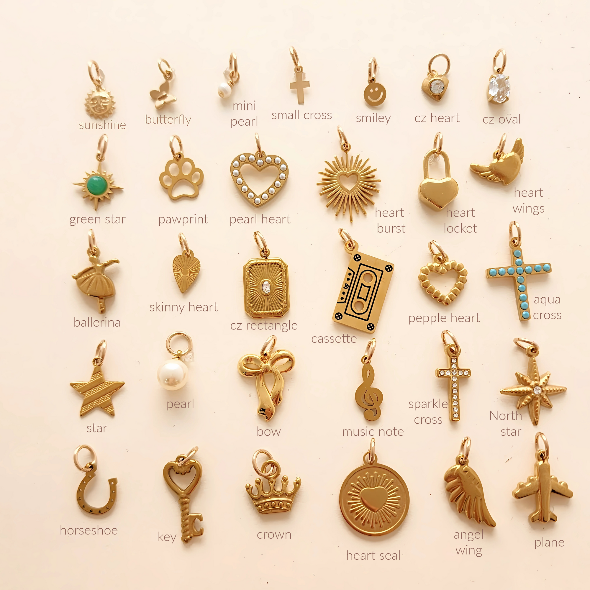 Collection of various gold pendants on a white background with labels.