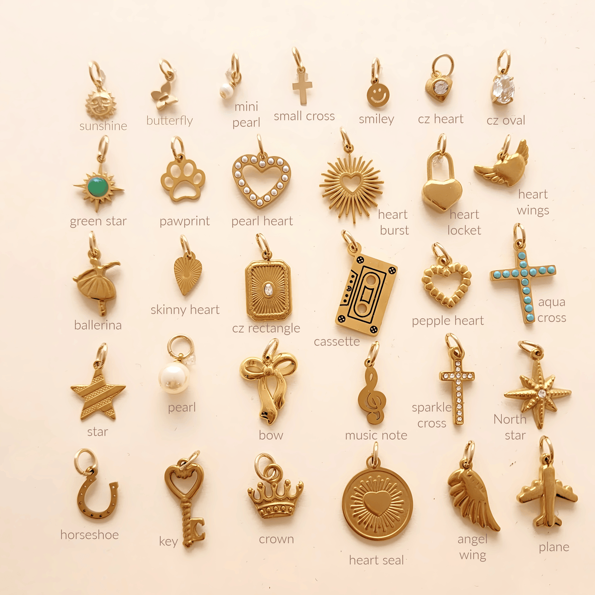 Collection of various gold pendants on a white background with labels.