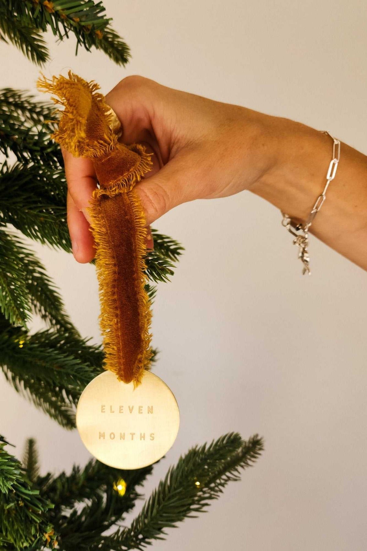 Set of 12 brass first year baby milestone ornaments engraved with months and personalized milestones