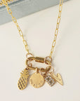 Gold necklace with various charms on a light background