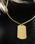 Gold necklace with a dog tag on a black background