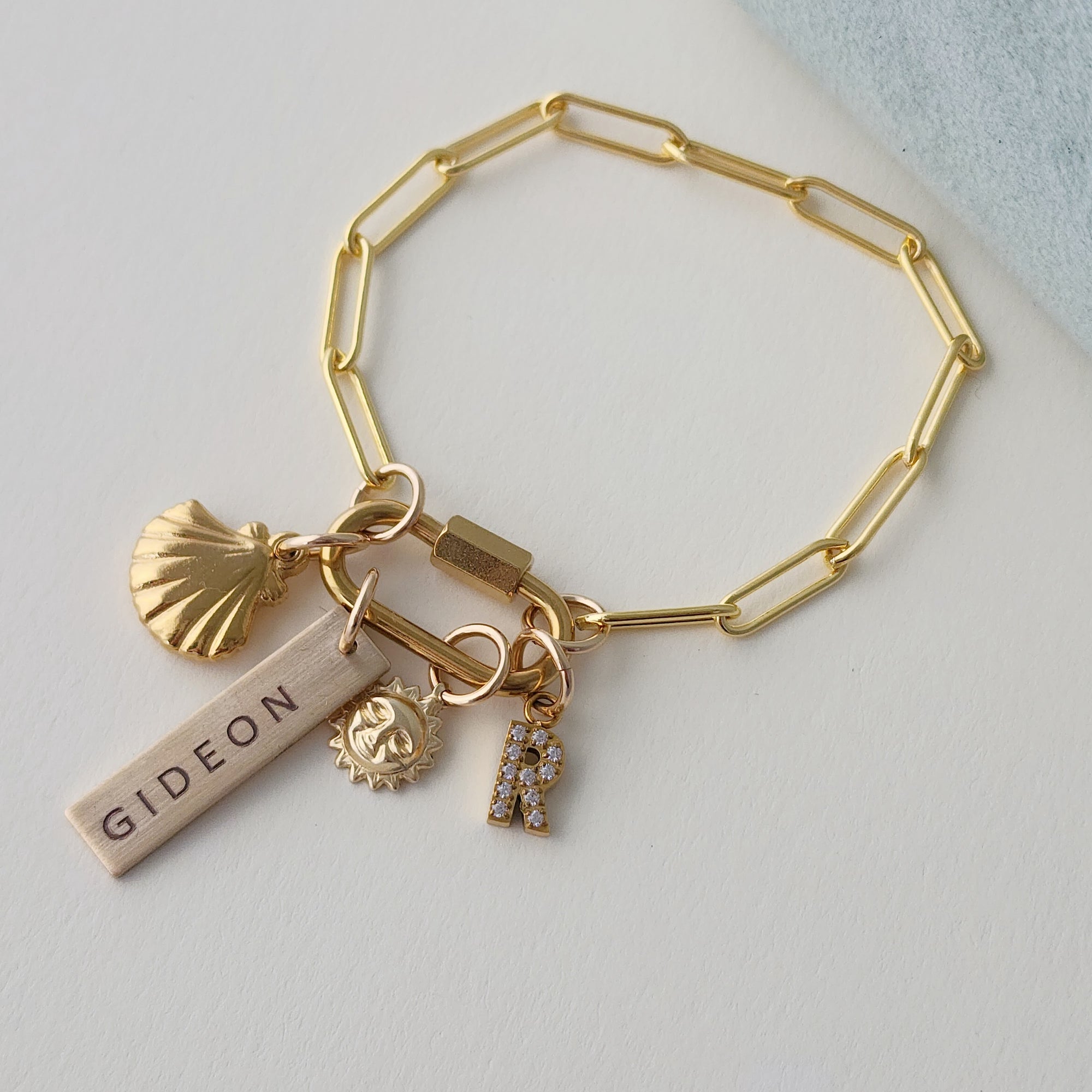 Gold bracelet with charms on a light gray background