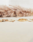 Gold bracelets on a white surface with a fur background