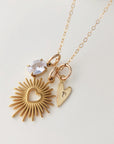 Gold necklace with heart-shaped pendants on a light gray background