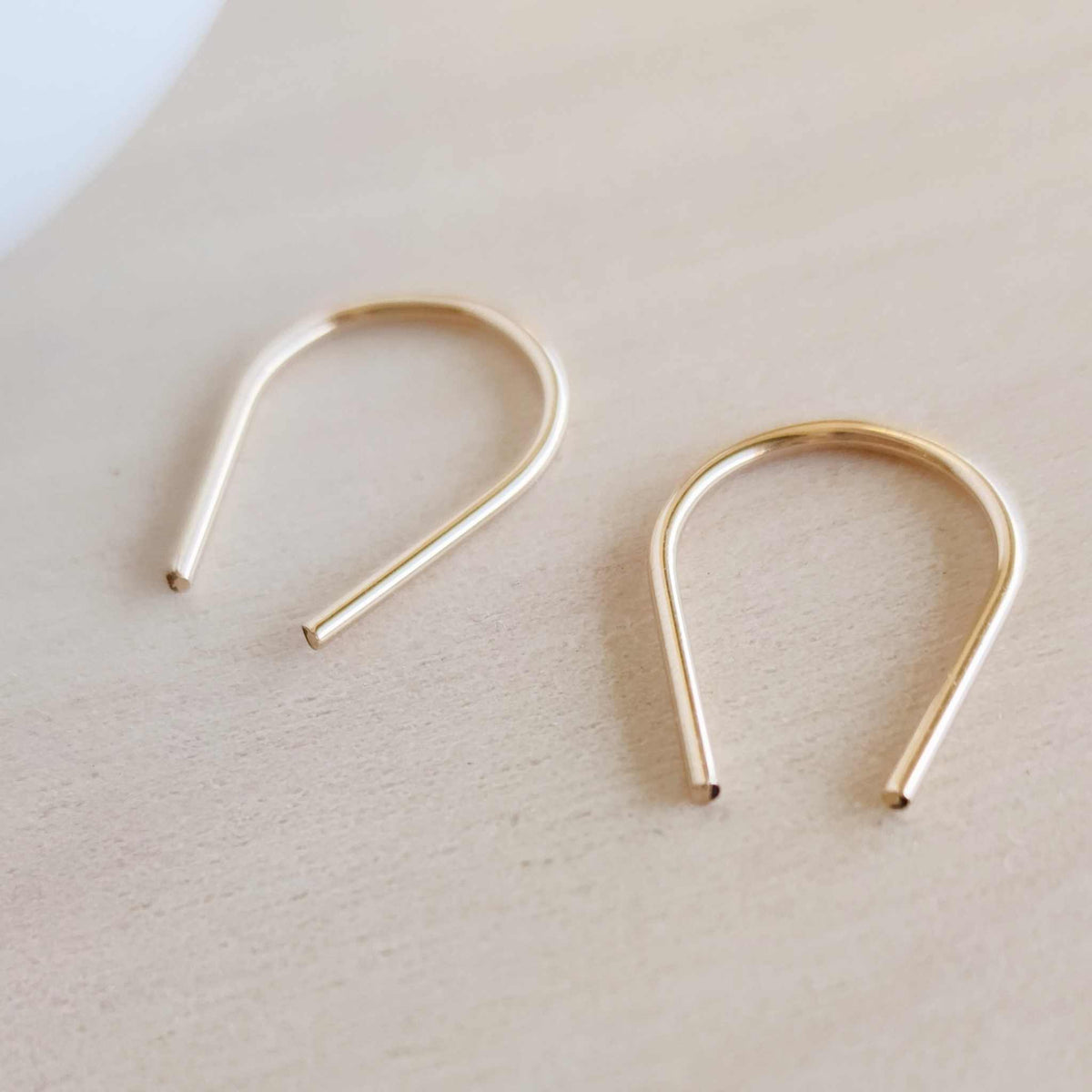 Minimalist 14K gold-filled arch earrings with sleek U-shaped design, lightweight and tarnish-resistant for everyday wear