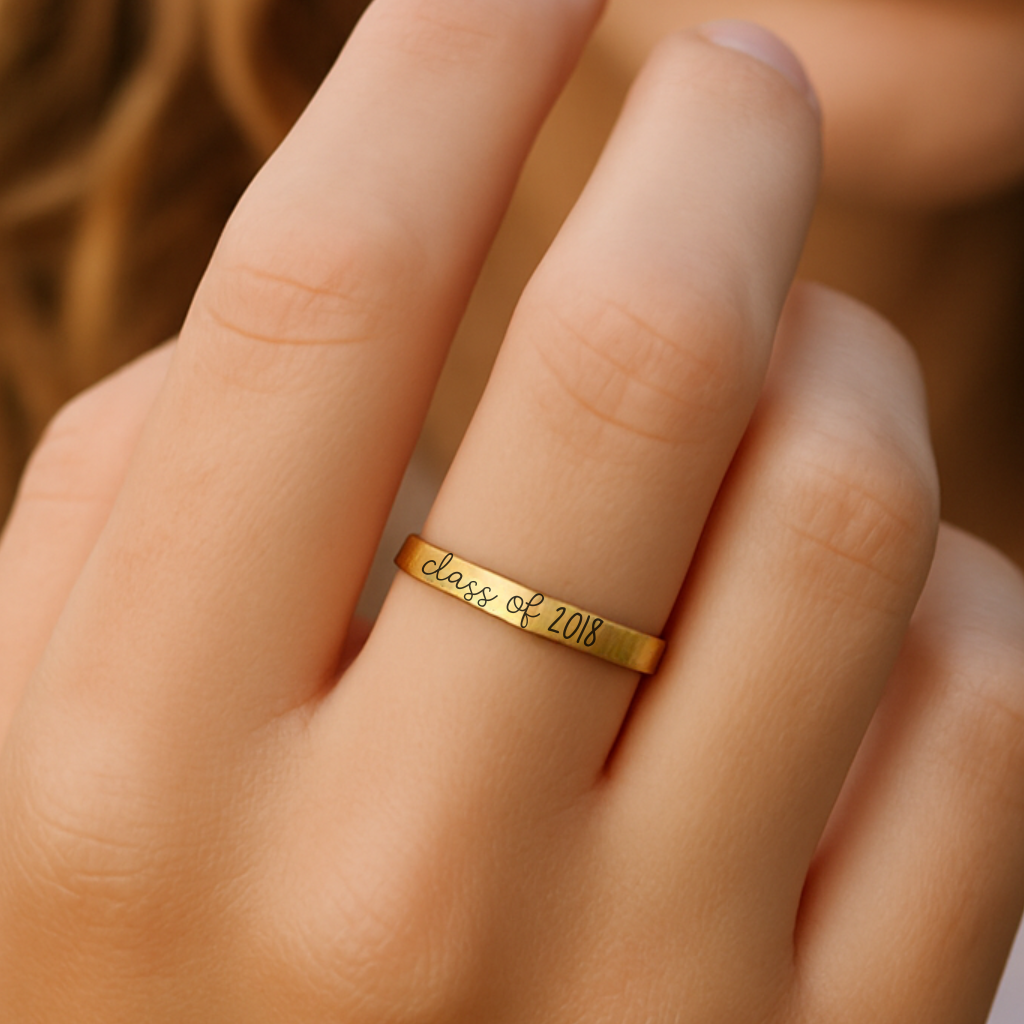 Gold ring with 'Class of 2018' engraving on a person's finger