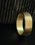 Gold ring on a textured black surface