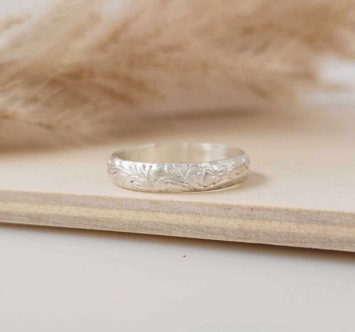 handcrafted silver floral ring with intricate engraved flower pattern and polished finish
