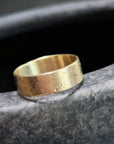 Gold ring on a dark stone surface