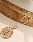 Necklace with a gold pendant on a wooden surface