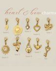 Gold heart and bow charms on a beige background with labels.