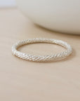 a sterling silver sparkle ring on a tan background