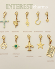 Collection of gold charms with various designs on a beige background