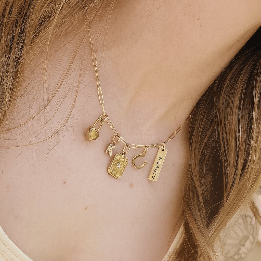 Gold necklace with various charms on a person's neck