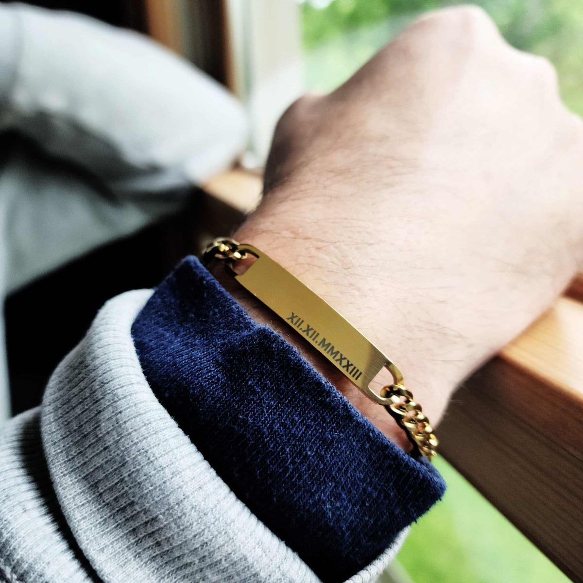 Gold bracelet on a wrist with a blurred background