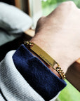 Gold bracelet on a wrist with a blurred background