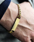 Gold bracelet with a bar clasp on a wrist