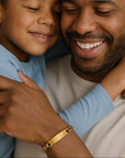 Man and child hugging, both smiling, with a warm and affectionate atmosphere.