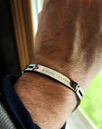 Bracelet with engraved names on a wrist, blurred background