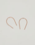 Minimalist gold U-shaped earring pair displayed on white background