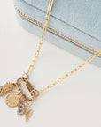 Gold necklace with charms on a light blue background