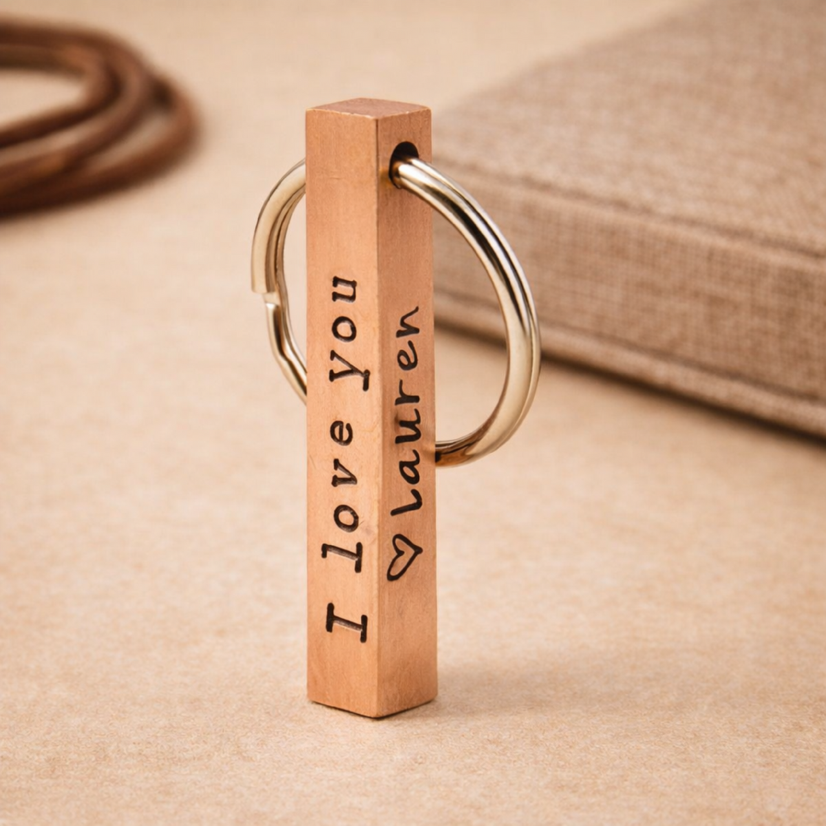 Four-sided solid copper bar keyring with personalized engravings in cursive and typewriter fonts